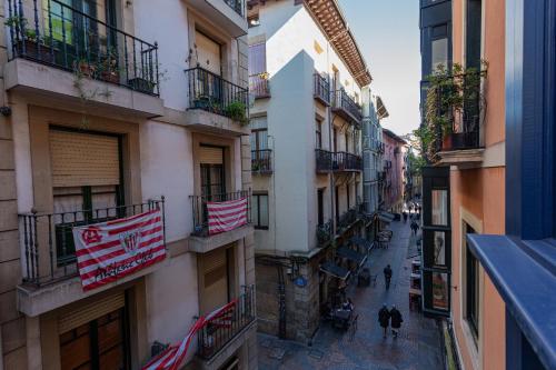 a city street with flags on the balconies of buildings at Casual Mardones in Bilbao