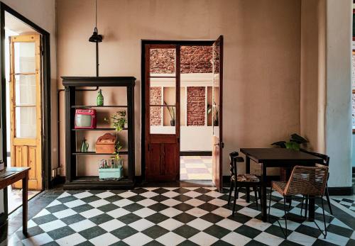 a room with a table and a checkerboard floor at La Botica de 1852 Hotel in Chascomús