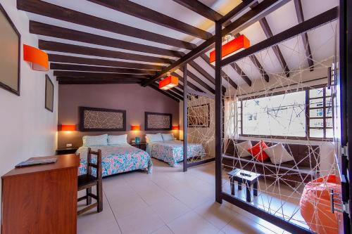 a bedroom with two beds and a desk in a room at Ayenda Mountain Hostels Manizales in Manizales