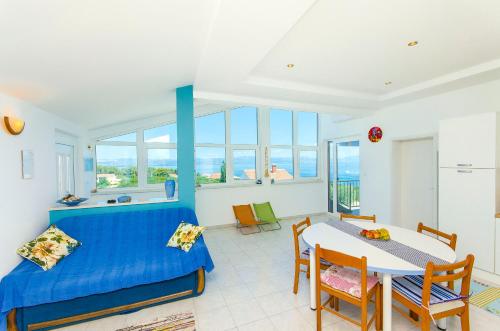 a bedroom with a blue bed and a table and chairs at Apartments Kazimir in Nečujam