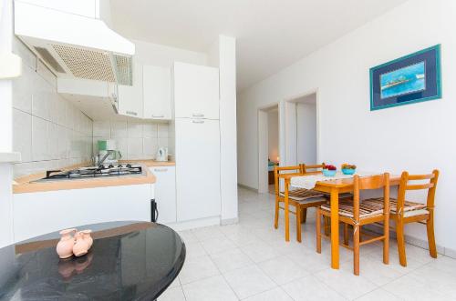 a kitchen and dining room with a table and chairs at Apartments Kazimir in Nečujam