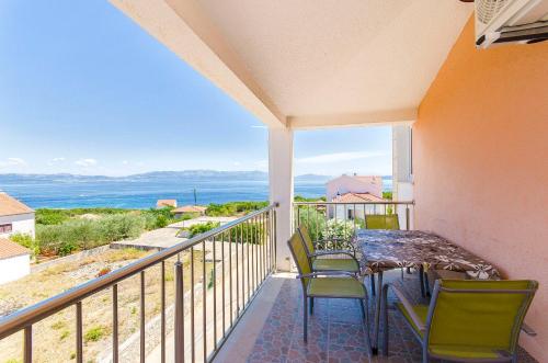 a balcony with a table and chairs and a view of the ocean at Apartments Kazimir in Nečujam