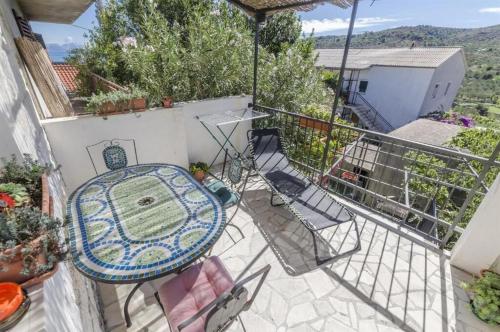 a patio with a table and chairs on a balcony at Apartments Anita in Slatine