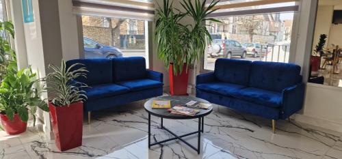 Dos sofás azules y una mesa en una habitación en Kyriad Direct Arpajon, en Arpajon