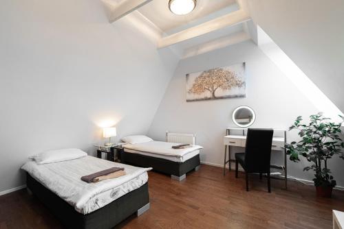 a bedroom with two beds and a desk and a table at AirHome - Raekoja Plats in Tallinn