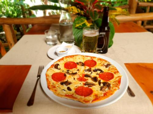 a pizza sitting on a plate on a table at Cariblue Beach and Jungle Resort in Puerto Viejo