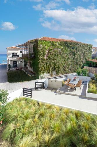 a building with a patio with a table and chairs at Araliki Suites in Polykhrono