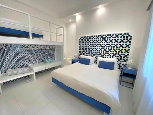 a bedroom with a bed with a blue and white headboard at MARILISE - La maison blue private garden & terrace in Meta