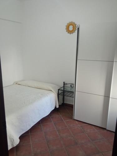 a small bedroom with a bed and a refrigerator at El Corchuelo in Corteconcepción
