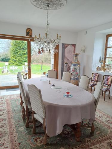 a dining room with a white table and chairs at chez céline in Sens-de-Bretagne