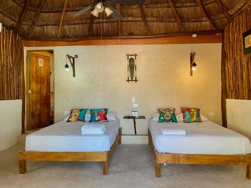 a bedroom with two beds in a room at Cabañas Frida in Chelem