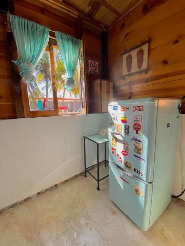 a kitchen with a refrigerator and a table at Cabañas Frida in Chelem
