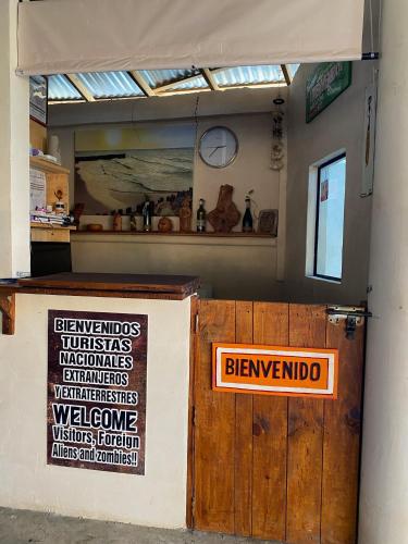 a sign on a wall next to a wooden door at Cabañas Frida in Chelem