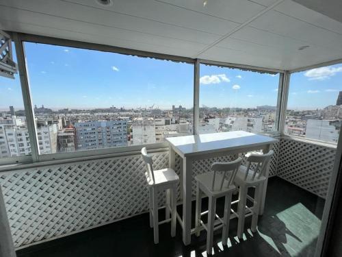 Un balcón con 2 sillas y una mesa con vistas. en Recoleta Posada en Buenos Aires