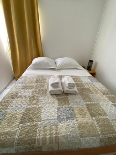 1 dormitorio con 1 cama con 2 toallas en Appartement moderne, 2 chambres, proche aéroport • CHU • port en Les Abymes