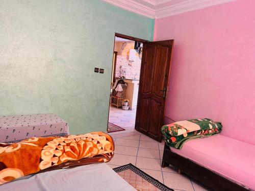a room with pink and green walls and a bed at Atlantic house in Tamraght Ouzdar