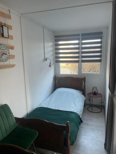 a small bedroom with a bed and a window at Het Hongaarse Vissershuisje in Dunaszekcső