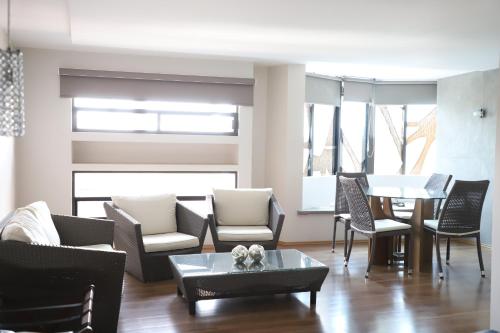 a living room with chairs and a table and a dining room at Hotel Posada Tulancingo in Tulancingo