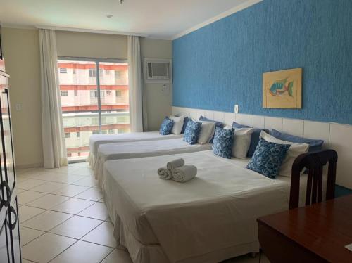 Habitación de hotel con 2 camas y paredes azules en Acrópolis Marina Hotel, en Angra dos Reis