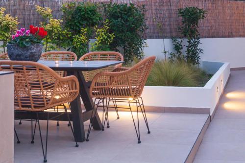 a patio with a table and chairs and flowers at Araliki Suites in Polykhrono
