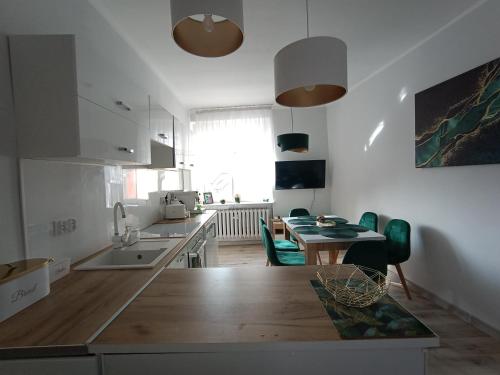 a kitchen with a table and a dining room at Szmaragdowy apartament in Tarnowskie Góry