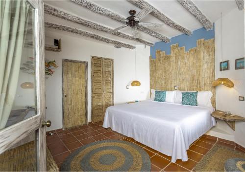 1 dormitorio con 1 cama blanca en una habitación en Holbox Dream Beachfront Hotel, en Isla Holbox