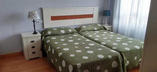 um quarto com uma cama e uma mesa com um candeeiro em Apartamento el Peral A em Colombres