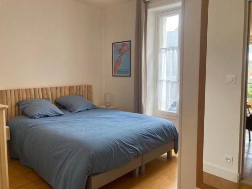 ディナールにある27 boulevard Féartのベッドルーム1室(青いシーツと窓付)