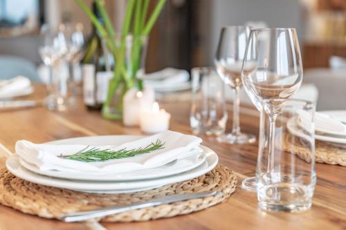 a wooden table with white plates and wine glasses at Purple Haze By AirCasa in Nairobi