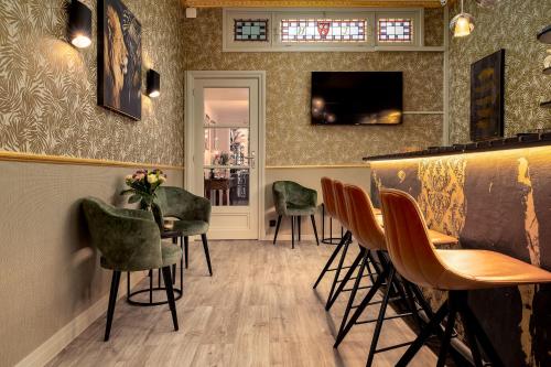 un bar avec des chaises vertes et un comptoir dans l'établissement Hotel Jacobs, à Bruges
