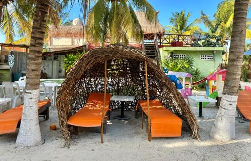 a gazebo with chairs and tables and palm trees at Cabañas Frida in Chelem