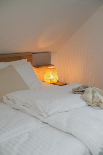 a white bed with a lamp on a table at Chata Jarabáček in Loučná nad Desnou