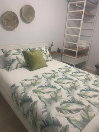 Schlafzimmer mit einem Bett mit einer grünen und weißen Bettdecke in der Unterkunft Gosol Lemon in Sanlúcar de Barrameda