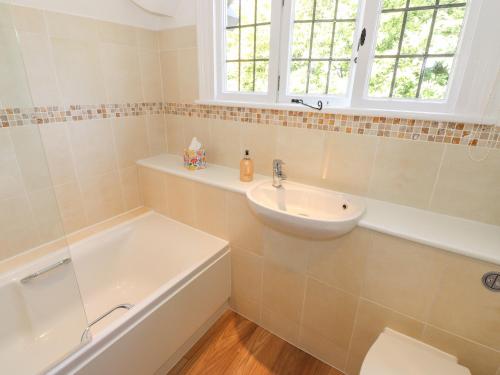 a bathroom with a sink and a toilet and a tub at Brunton Lodge in Bowness-on-Windermere