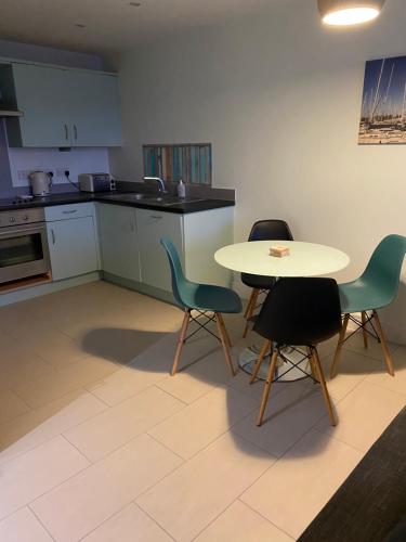kuchnia ze stołem, 2 krzesłami i stołem w obiekcie Stunning Marina apartment Gosport Portsmouth w mieście Gosport