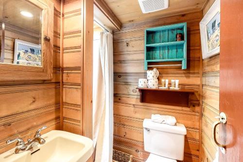 La salle de bains est pourvue de murs en bois, de toilettes et d'un lavabo. dans l'établissement Beach Camp, à Eastham