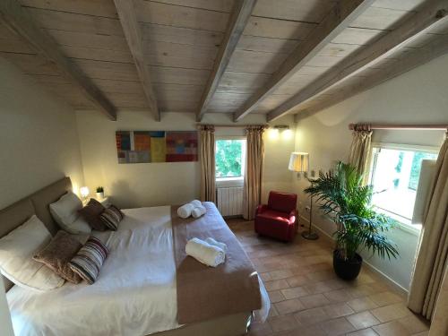 a bedroom with a large bed and a red chair at B&B Can Jan in Sant Ferriol