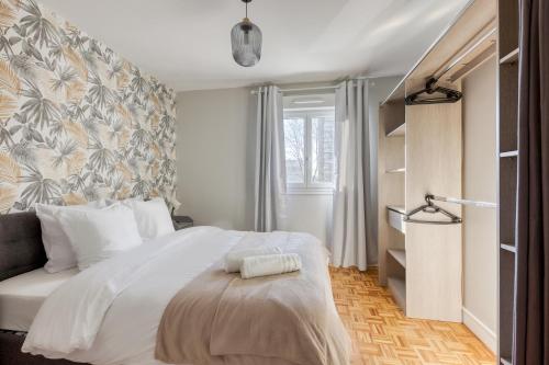 a bedroom with a large white bed and a window at Spacieux 3 pièces Paris / Disney in Noisy-le-Grand