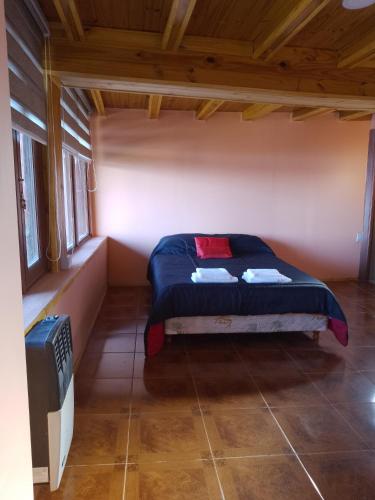 1 dormitorio con 1 cama en una habitación pequeña en Lecao en Ushuaia