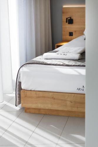 a bedroom with a bed with a wooden foot board at Araliki Suites in Polykhrono