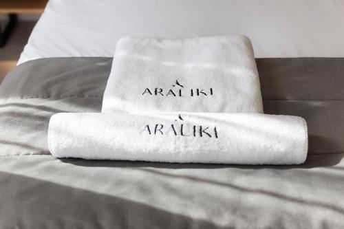 a towel on a bed with the words anal kiss andarius at Araliki Suites in Polykhrono