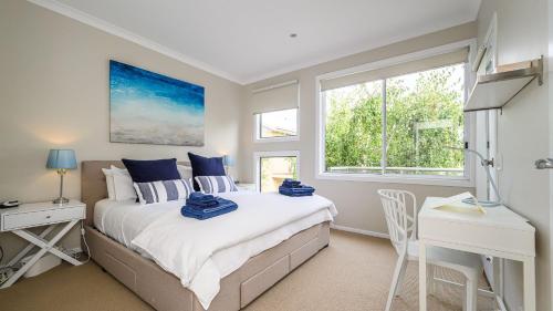 a bedroom with a bed and a desk and a window at Sandpiper 9 - Close to Town and Beach in Inverloch