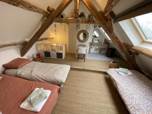 a attic bedroom with two beds in a room at La Courmonière in Courmont