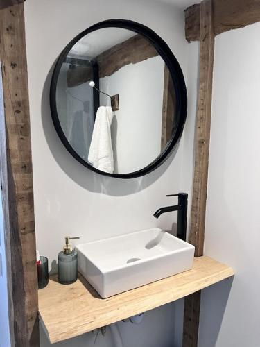 une salle de bain avec un lavabo blanc et un miroir dans l'établissement La Courmonière, à Courmont