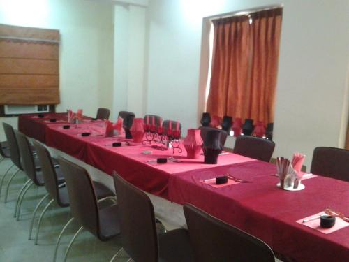 a room with tables and chairs with red table cloth at Hotel Maiden Residency in Ghaziabad