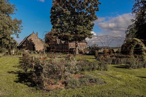 a garden with an old church and a playground at Cabane de l'R-mitage in Modave