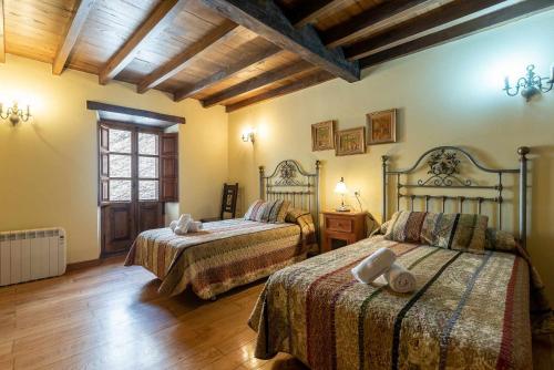 una camera da letto con due letti e pavimento in legno di Casa vacacional Dario a Rales