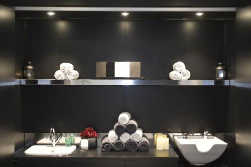 a black bathroom with two sinks and towels at The Lodge at Kingswood in Epsom