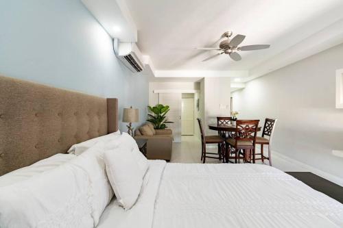 1 Schlafzimmer mit einem weißen Bett und einem Esszimmer in der Unterkunft City Edge La Vie in Kingston