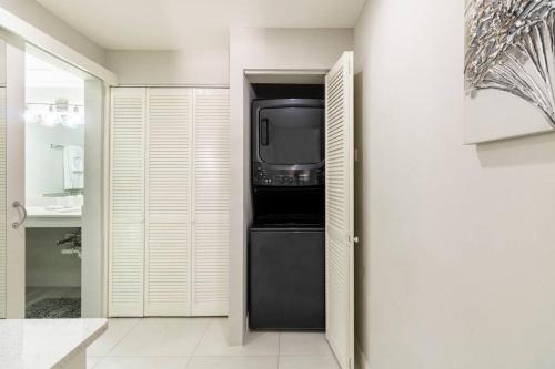 a kitchen with a black refrigerator with a tv in it at City Edge La Vie in Kingston